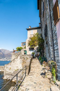 Corenno Plinio with stone houses, plants and flowers