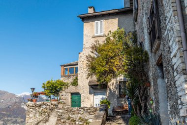 Corenno Plinio with stone houses, plants and flowers