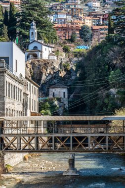 Bellano 'da arka planda bir kilise olan üstü kapalı bir köprü.