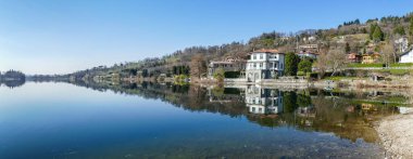 Evler ve bitkiler Pusiano Gölü 'nün suyuna yansıyor.