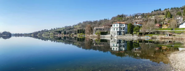 Evler ve bitkiler Pusiano Gölü 'nün suyuna yansıyor.