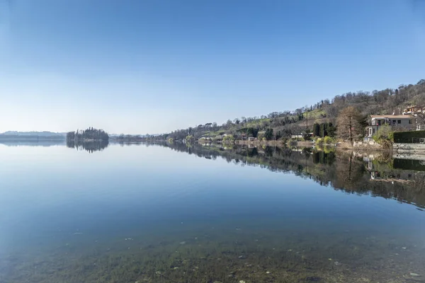 Evler ve bitkiler Pusiano Gölü 'nün suyuna yansıyor.