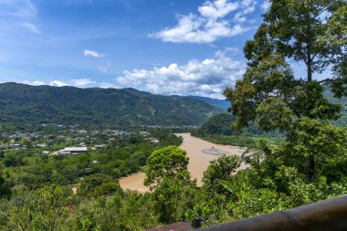 Tingo Mara ve Ro Monzn 'un panoramik şehir manzarası parlak mavi gökyüzünün altındaki yemyeşil dağların yanında. Seyahat, doğa, turizm ve çevre temaları için ideal canlı tropikal manzara.