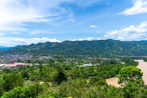 Tingo Mara ve Ro Monzn 'un panoramik şehir manzarası parlak mavi gökyüzünün altındaki yemyeşil dağların yanında. Seyahat, doğa, turizm ve çevre temaları için ideal canlı tropikal manzara.