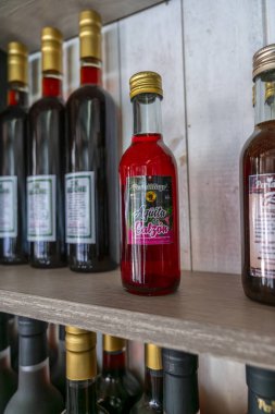 Bir mağaza rafında kırmızı sıvıyla sergilenen Peru Amazon içecek şişesi, orman kültürünü, bölgesel ürünleri ve yağmur ormanlarından gelen geleneksel lezzetleri ön plana çıkaran bir yazı ortamında görünür markalaşmayı gösteriyor..