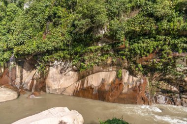 Tingo Mara, Peru 'daki Amazon yağmur ormanları kayalıkları, yemyeşil bitki örtüsü, akan nehir ve erozyonla şekillenen doğal kaya oluşumları, doğa ve seyahat temaları için ideal canlı bir tropikal manzara yaratıyor..