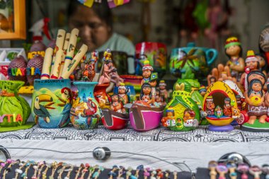Peru yerel kültürünü temsil eden renkli Amazon seramik figürleri ve el sanatları bir pazar masasında sergilenmektedir. Canlı tasarımlar ve geleneksel motifler yerel zanaat ve kültür mirasını ön plana çıkarıyor.