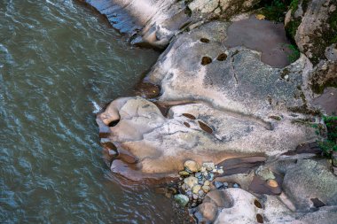 Peru Tingo Mara 'da akan nehir suyuyla şekillenen aşınmış kaya oluşumları. Doğal dokular ve desenler Amazon yağmur ormanlarındaki jeolojik süreçleri ortaya çıkararak ayrıntılı ve organik bir manzara yaratıyor..