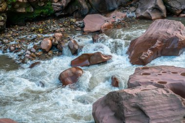Peru 'nun Tingo Maria ormanındaki büyük aşınmış kayaların arasından akan nehir güçlü akıntılar, engebeli arazi, doğal jeoloji ve yağmur ormanlarının dinamik su yolları sergiliyor..