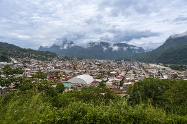 Peru 'nun Tingo Maria kentinin panoramik manzarası bereketli dağlar, yağmur ormanları bitki örtüsü ve tropikal vadi atmosferini yükselten bulutlarla çevrili yoğun kentsel gelişimi gösteriyor..