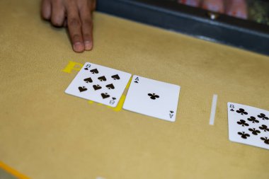 Dağıtıcı kumarhane masasındaki bakara kartlarını işaret ediyor, kumar konsepti bahis, şans, strateji, para, oyun ve lüks iç mekan..