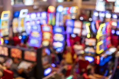 Kumar makineleri, neon ışıkları ve siluetleri olan bulanık bir kumarhane. Renkli ışıltı, gece hayatı, eğlence, eğlence, eğlence, şans ve risk ile bağlantılı soyut bir kumar ortamı yaratır.