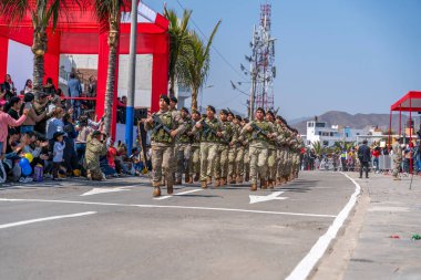 Kamu töreni sırasında Peru 'da askeri disiplin ve milli gururu gösteren izleyiciler, kamuya açık alanda kamuflaj üniforması giymiş askerler ve tüfeklerle yürüyüş yapıyorlar..