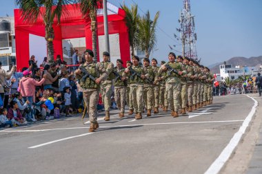 Kamu töreni sırasında Peru 'da askeri disiplin ve milli gururu gösteren izleyiciler, kamuya açık alanda kamuflaj üniforması giymiş askerler ve tüfeklerle yürüyüş yapıyorlar..