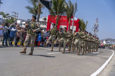 Kamu töreni sırasında Peru 'da askeri disiplin ve milli gururu gösteren izleyiciler, kamuya açık alanda kamuflaj üniforması giymiş askerler ve tüfeklerle yürüyüş yapıyorlar..