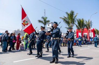Peru hava kuvvetleri askerleri bir sivil geçit töreninde tüfekler ve ulusal bayrak taşıyarak sıraya girdiler. İzleyiciler, Peru 'daki askeri disiplin, vatanseverlik ve kurumsal varlığı göstererek sokaktan izliyorlar..