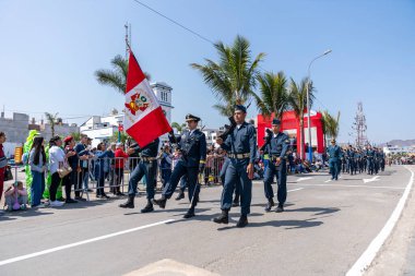 Peru hava kuvvetleri askerleri bir sivil geçit töreninde tüfekler ve ulusal bayrak taşıyarak sıraya girdiler. İzleyiciler, Peru 'daki askeri disiplin, vatanseverlik ve kurumsal varlığı göstererek sokaktan izliyorlar..