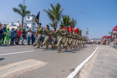 Kamu töreni sırasında Peru 'da askeri disiplin ve milli gururu gösteren izleyiciler, kamuya açık alanda kamuflaj üniforması giymiş askerler ve tüfeklerle yürüyüş yapıyorlar..