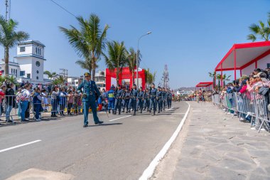 Peru hava kuvvetleri askerleri bir sivil geçit töreninde tüfekler ve ulusal bayrak taşıyarak sıraya girdiler. İzleyiciler, Peru 'daki askeri disiplin, vatanseverlik ve kurumsal varlığı göstererek sokaktan izliyorlar..
