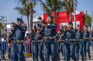Peru hava kuvvetleri askerleri bir sivil geçit töreninde tüfekler ve ulusal bayrak taşıyarak sıraya girdiler. İzleyiciler, Peru 'daki askeri disiplin, vatanseverlik ve kurumsal varlığı göstererek sokaktan izliyorlar..