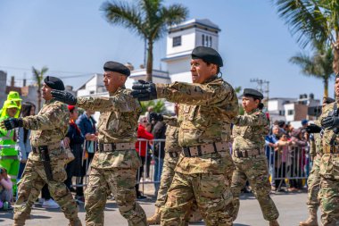 Kamu töreni sırasında Peru 'da askeri disiplin ve milli gururu gösteren izleyiciler, kamuya açık alanda kamuflaj üniforması giymiş askerler ve tüfeklerle yürüyüş yapıyorlar..