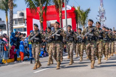 Kamu töreni sırasında Peru 'da askeri disiplin ve milli gururu gösteren izleyiciler, kamuya açık alanda kamuflaj üniforması giymiş askerler ve tüfeklerle yürüyüş yapıyorlar..