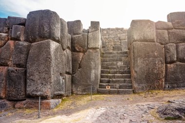 Cusco Peru 'da devasa İnka taş duvarları olan Sacsayhuaman törensel tapınağı. Antik İspanyol öncesi mimari, kusursuz taş işçiliği ve tarihi And mirası, ikonik arkeolojik alan ve turizm simgesi.