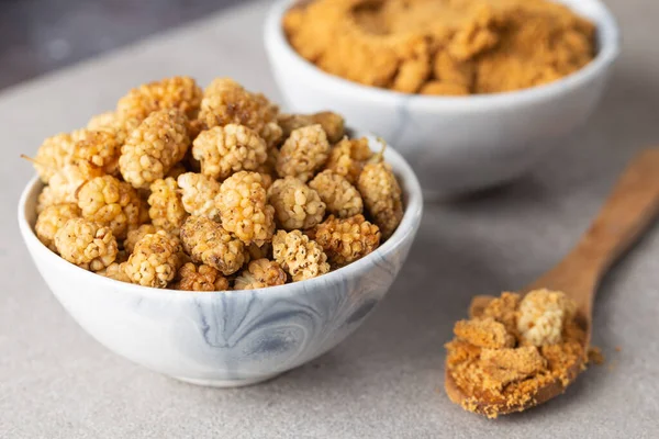 Dut tozu. Meyve tozu. Bir kase kurutulmuş dut tozu ve kurutulmuş dut meyvesi..