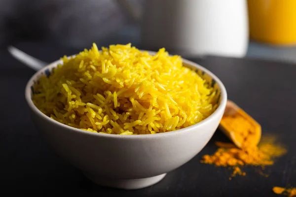 Basmati pilavından yapılan bir kase sarı pirinç ve zerdeçal tozu.