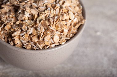 Seramik kasede sağlıklı mısır gevreği. Çavdar gevreği taştan arka planda bir kasede..