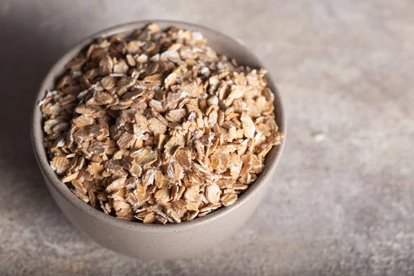 Seramik kasede sağlıklı mısır gevreği. Çavdar gevreği taştan arka planda bir kasede..