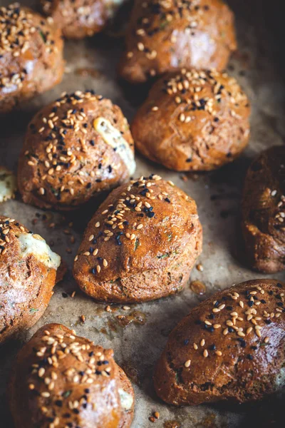 Homemade Pastries with Sesame Seeds on Baking Paper Sheet with Tray. Turkish pogaca (pastry) made with einkorn flour.