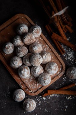 Ahşap zemin üzerinde şeker tozu olan tarçınlı kurabiyeler. 