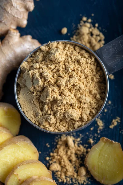 Ginger root and ginger powder in the bowl. Fresh ginger root and ground ginger spice.