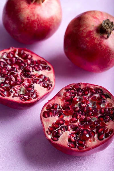 Pomegranates cut open with pomegrante seeds. Fruit minimalism creative concept.