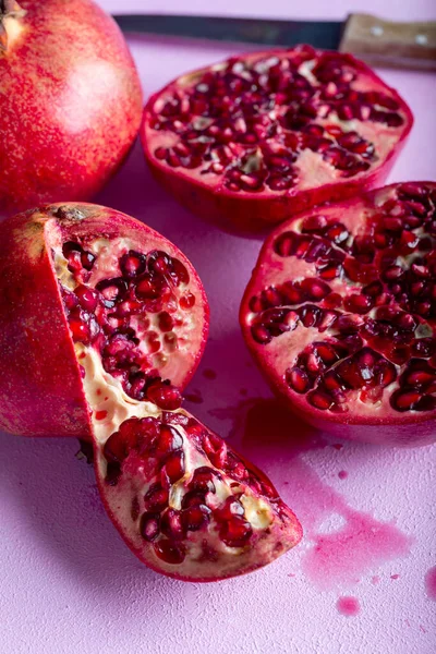 Pomegranates cut open with pomegrante seeds. Fruit minimalism creative concept.