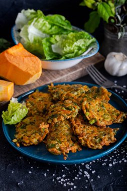 Balkabağı, soğan ve dereotlu sebze köftesi. Siyah arkaplanda kabak böreği.