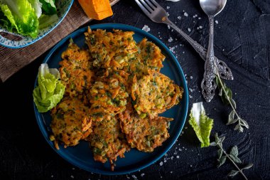 Balkabağı, soğan ve dereotlu sebze köftesi. Siyah arkaplanda kabak böreği.