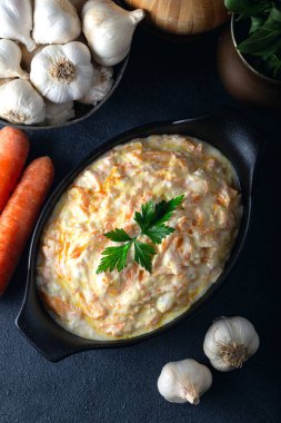 Seramik kasede havuç taratörü ve arka planda sebze. Havuç salatası ve sarımsaklı yoğurt..