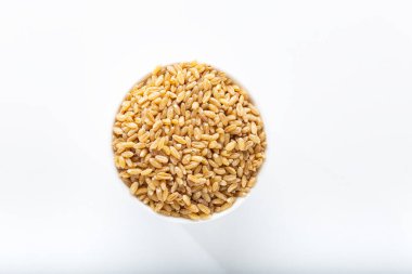 Beyaz arka planda izole edilmiş beyaz seramik kasede pişirilmemiş bulgur buğdayı.