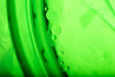 Su yüzeyine yağ damlıyor. Özet ve özgeçmiş. Yeşil arkaplan