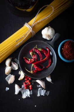 Çiğ makarna, kurutulmuş kırmızı biber, sarımsak ve zeytinyağı. Makarna sosu malzemesi.