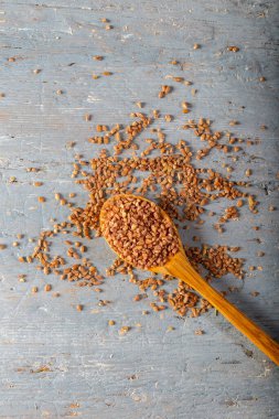 Ahşap arka planda tahta kaşıkta doğal Einkorn bulgur. Üst Manzara. (Siyez).