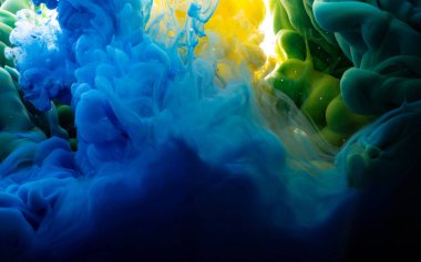 Suda sarı, mavi ve yeşil mürekkep. Mürekkep suya düşer. Soyut arkaplan. 