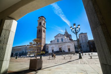 Torino Katedrali 'nin (Duomo di San Giovanni Battista) gündüz görüntüsü ve ön plandaki kemer tarafından çerçevelenmiş tarihi çan kulesi. Torino, İtalya, 10.07.2025.
