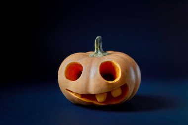 Gecenin karanlığında, mavi arka planda fotokopi alanı olan bir Jack O Feneri.