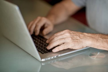 The old man hand typing with laptop in nature light clipart