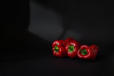 Siyah arkaplanda üç kırmızı biber.