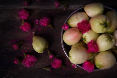 Güzel pembe Malezya elma çiçekleri ve ahşap masada Malezya elmaları, meyve fotoğrafçılığı, güzel natürmort fotoğrafçılığı.