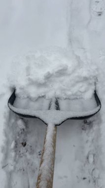 Yoldan kar küreyen bir küreğe yakın plan. Karlı bir kış sırasında karların temizlenmesi.